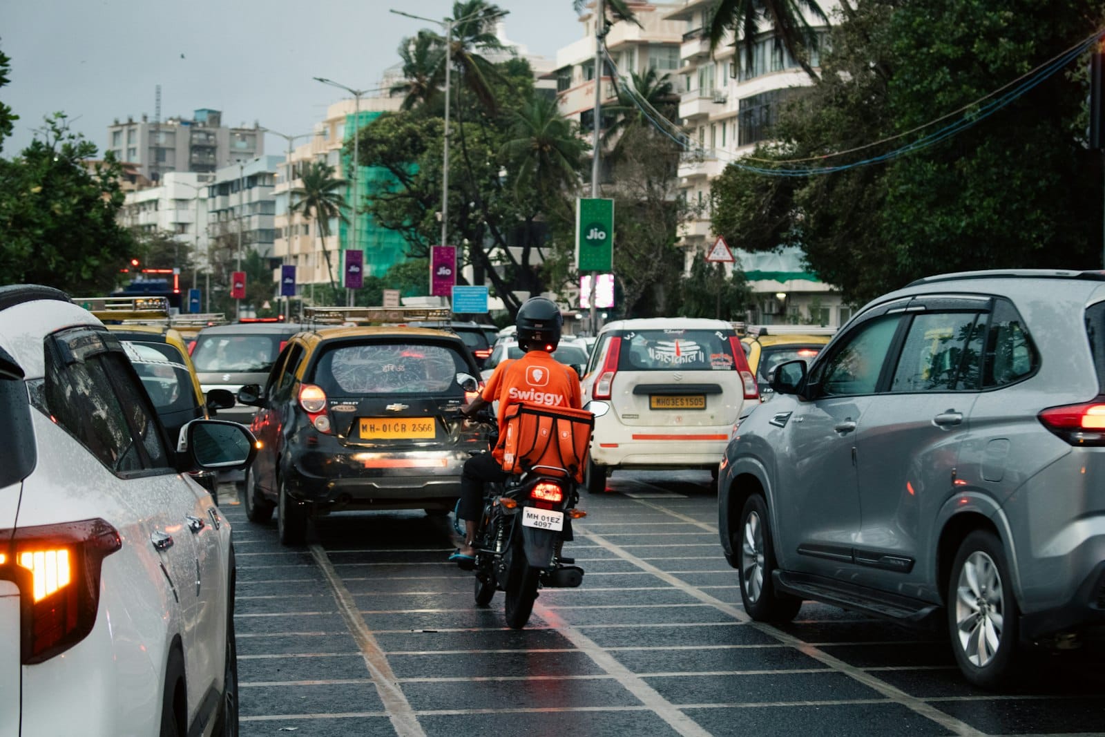 A Swiggy delivery rider waiting in heavy Mumbai traffic