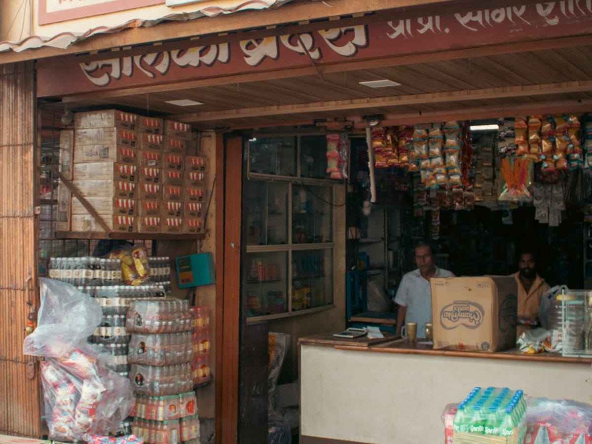 A neighbourhood kirana store in India with packaged goods stacked outside